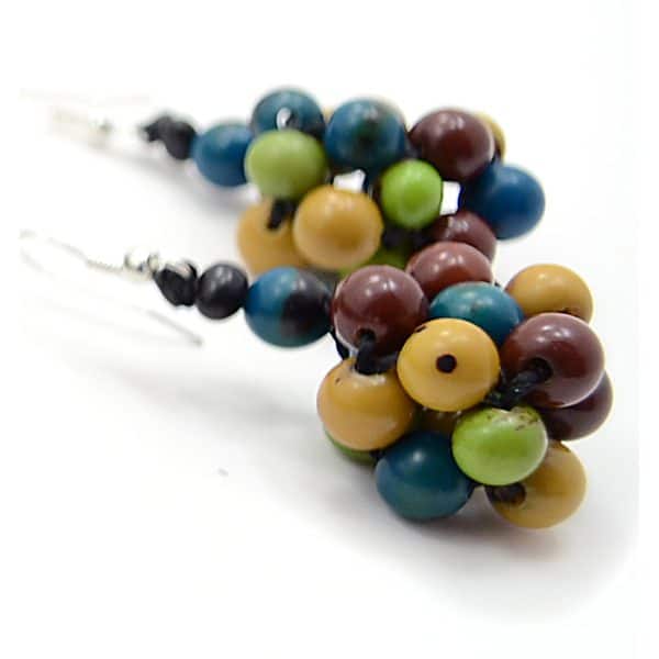 A picture of the plaited seed earrings, seed clusters with a bunch of different colored seeds, the colors of the seeds are pink, yellow, and red.